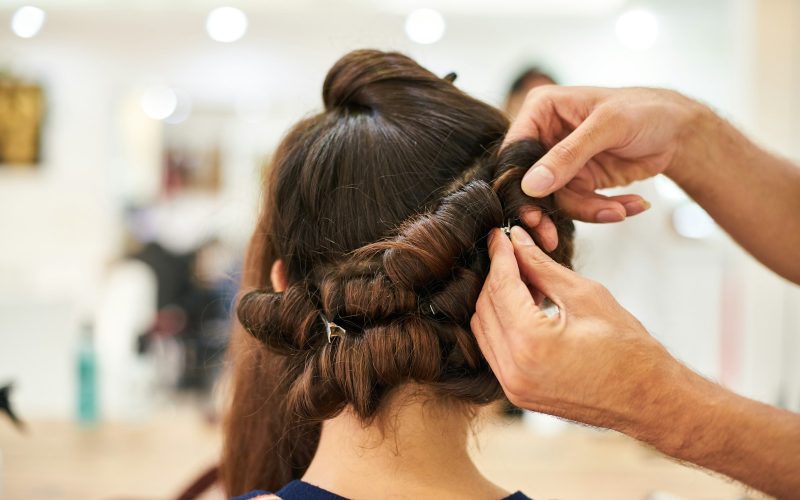 woman in blue shirt holding her hair