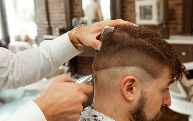 man in white dress shirt cutting hair of man