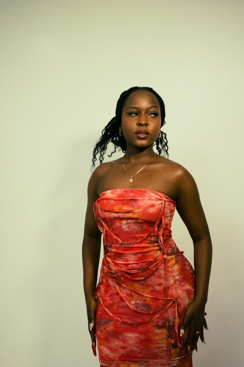 A woman in a red dress is posing.